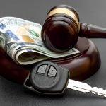 judge gavel with car key and money